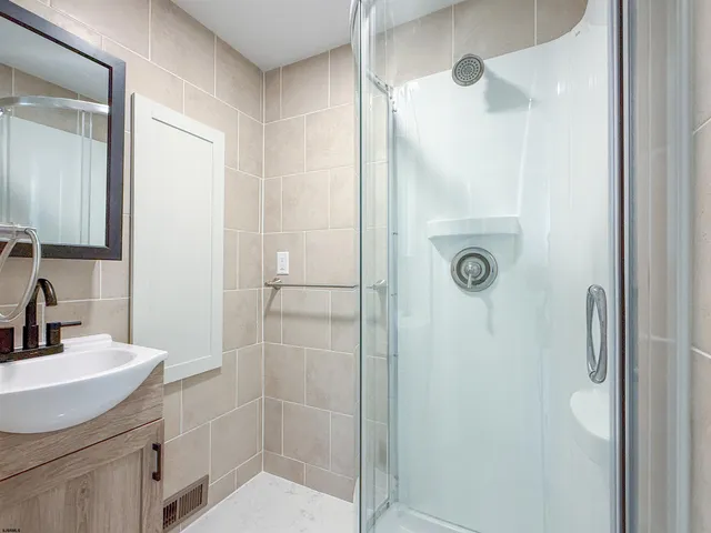 a bathroom with a shower sink and mirror