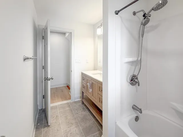 a bathroom with a tub shower and a sink