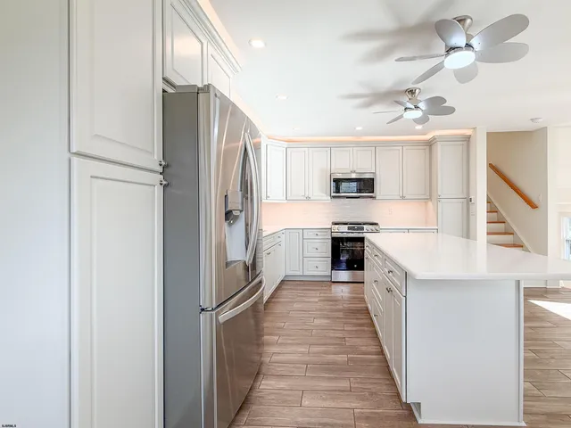a kitchen with kitchen island a counter top space stainless steel appliances and cabinets