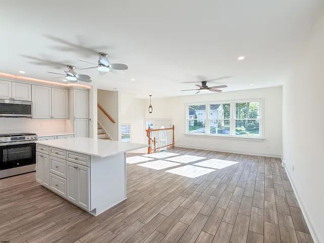 a kitchen with stainless steel appliances granite countertop a stove oven and a wooden floors