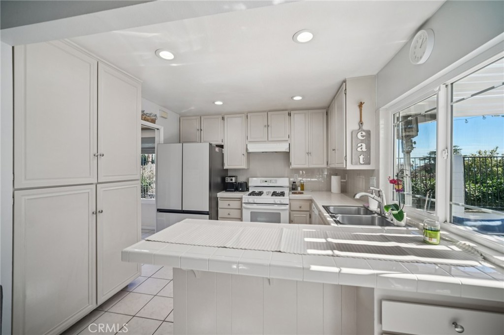 11461 Amigo Avenue Porter Ranch, CA 91326 - Photo 12 of 52 a kitchen with stainless steel appliances a refrigerator and a stove top oven