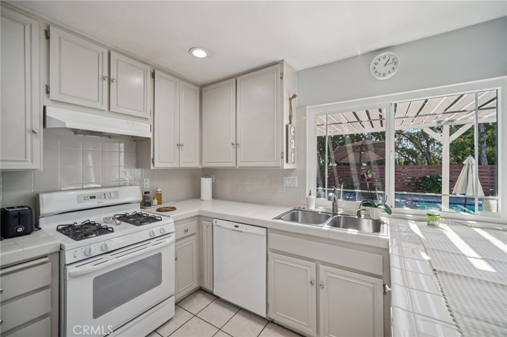 11461 Amigo Avenue Porter Ranch, CA 91326 - Photo 13 of 52 a kitchen with a sink stove and cabinets