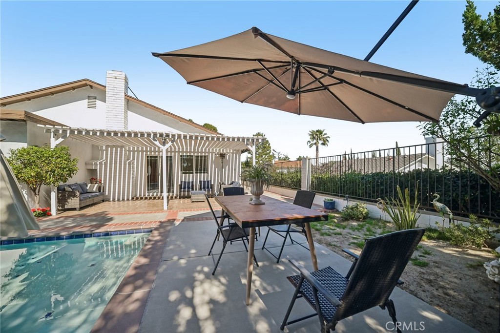 11461 Amigo Avenue Porter Ranch, CA 91326 - Photo 30 of 52 a patio with a table and chairs under an umbrella