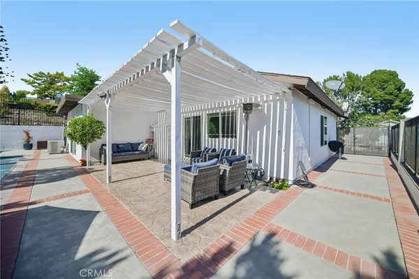 a view of patio with couches and chairs under an umbrella