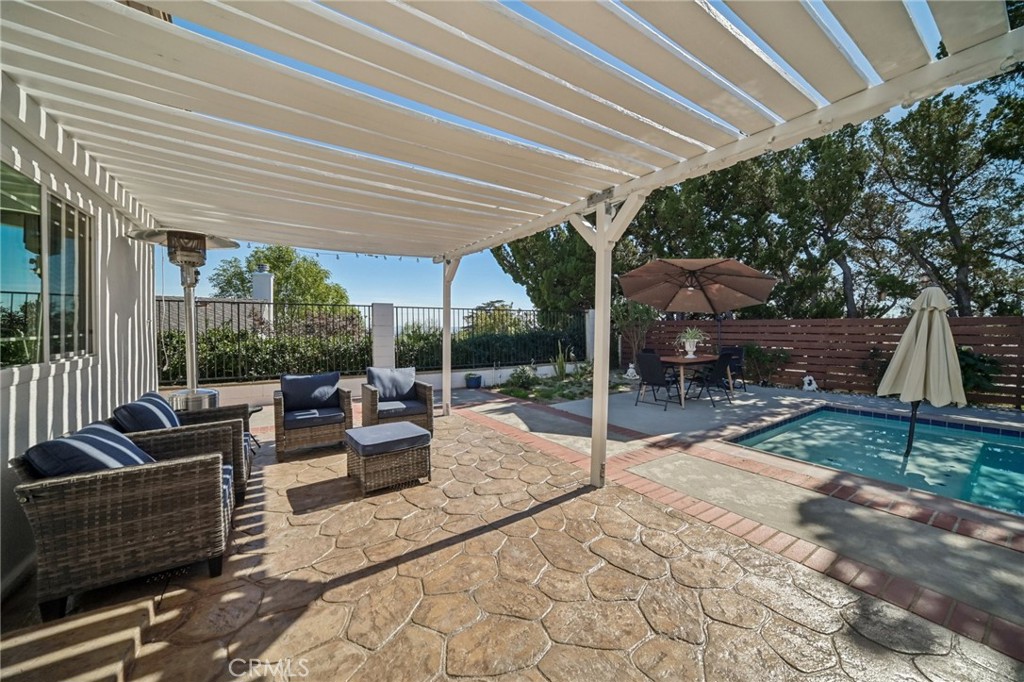 11461 Amigo Avenue Porter Ranch, CA 91326 - Photo 32 of 52 a view of patio with couches and chairs under an umbrella