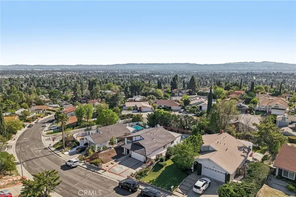 an aerial view of residential houses with outdoor space and trees