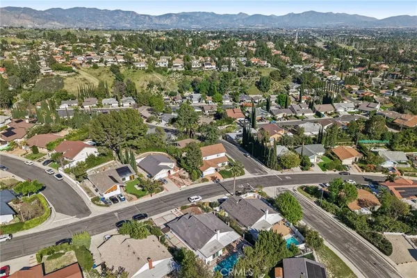 an aerial view of residential houses with outdoor space and trees