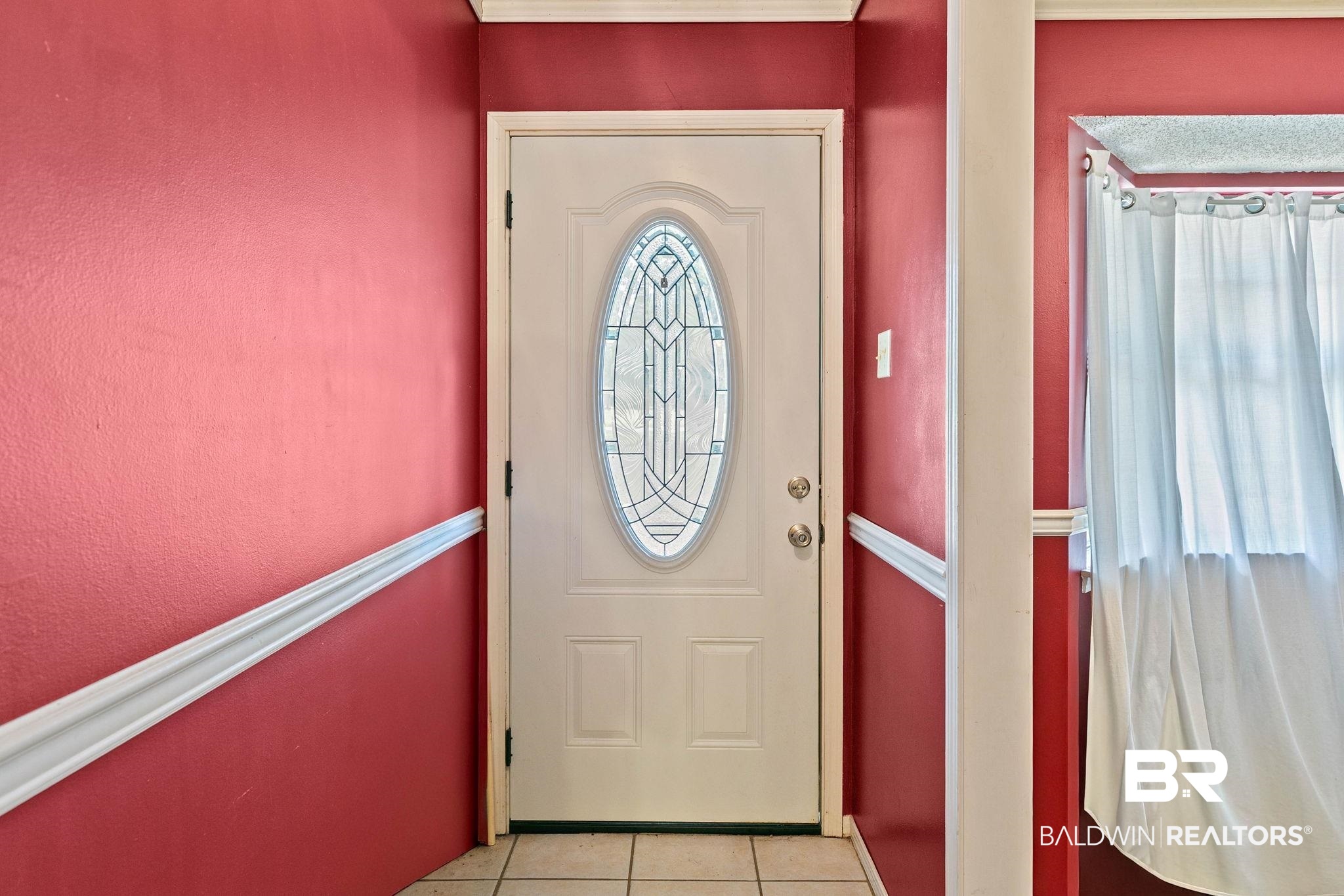 13653 Roberts Road Loxley, AL 36551 - Photo 6 of 33 Entry door featuring an oval leaded glass insert, white trim, and a decorative chair rail