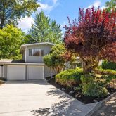 a front view of a house with a yard and trees