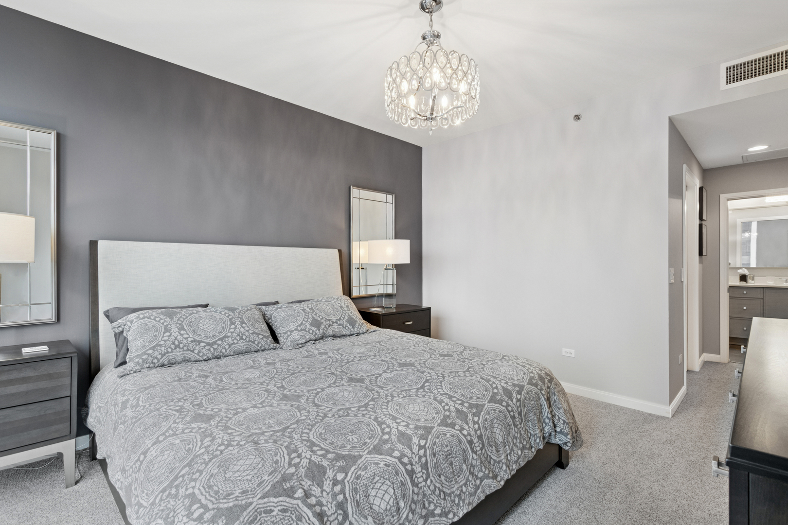 60 East Monroe Street, Unit 3402 Chicago, IL 60603 - Photo 13 of 31 a bedroom with a large bed and a chandelier