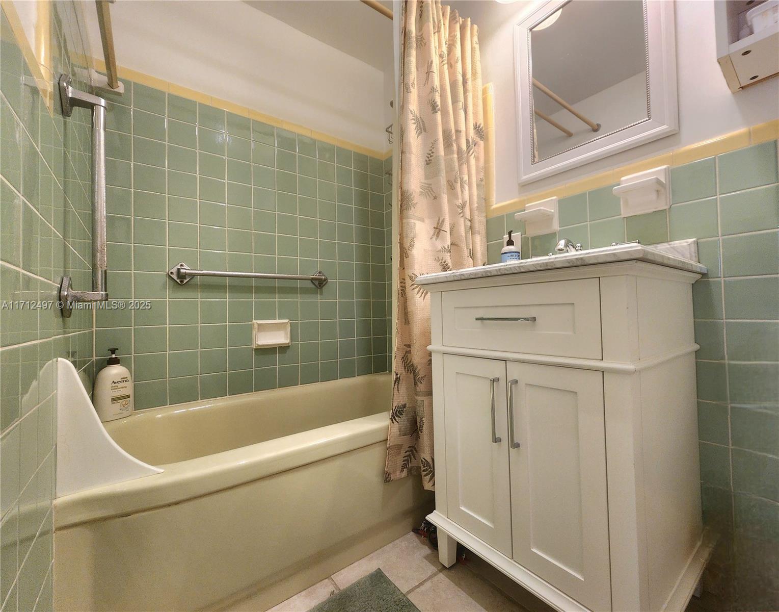 1504 South Surf Road, Unit 57 Hollywood, FL 33019 - Photo 23 of 27 a bathroom with a white bath tub a sink and a window