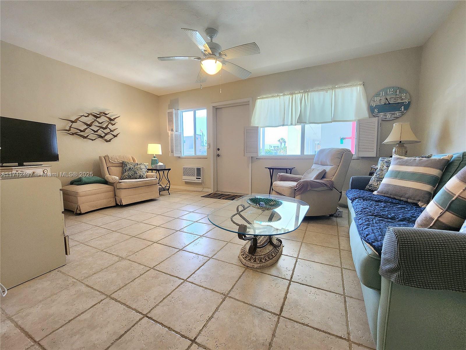 1504 South Surf Road, Unit 57 Hollywood, FL 33019 - Photo 8 of 27 a living room with furniture and a flat screen tv