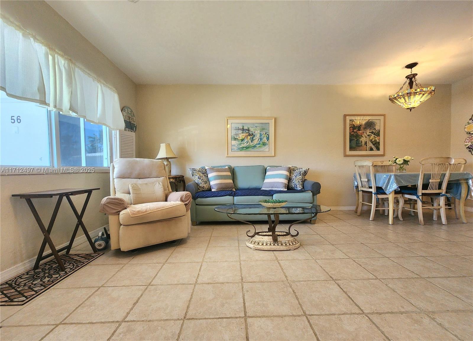 1504 South Surf Road, Unit 57 Hollywood, FL 33019 - Photo 10 of 27 a living room with furniture a rug and a wall painting