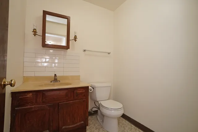a bathroom with a granite countertop toilet sink and mirror