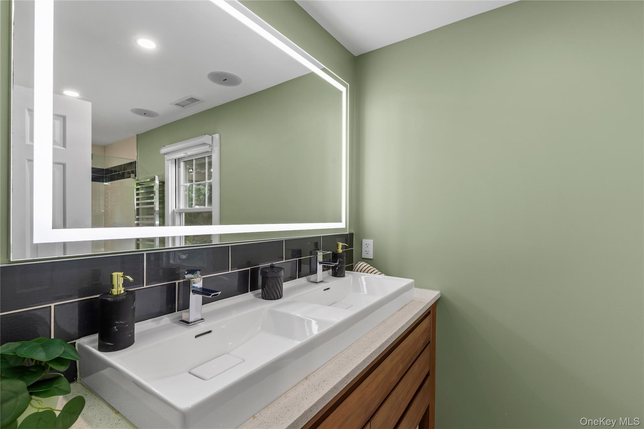 19 John Jay Place Rye, NY 10580 - Photo 28 of 45 The renovated primary bathroom is generous, airy, and bright with a double vanity and storage drawers.