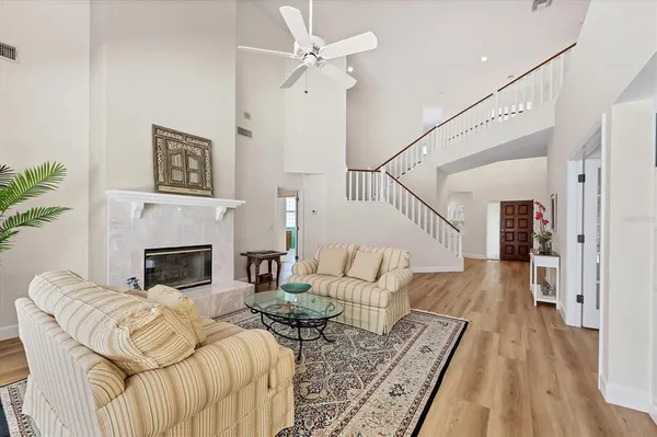 a kitchen with stainless steel appliances granite countertop a sink a stove a refrigerator and white cabinets with wooden floor