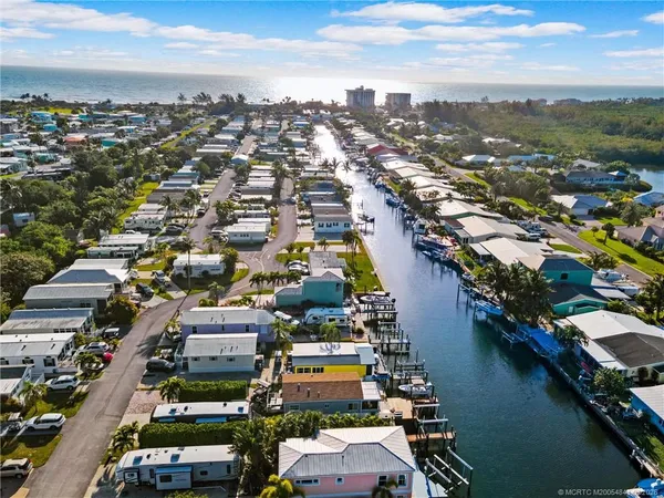 an aerial view of a city with lots of residential buildings ocean and trees