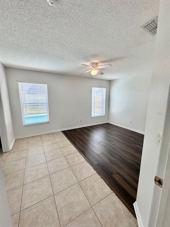 147 South Roma Way Kissimmee, FL 34746 - Photo 6 of 11 an empty room with wooden floor and windows
