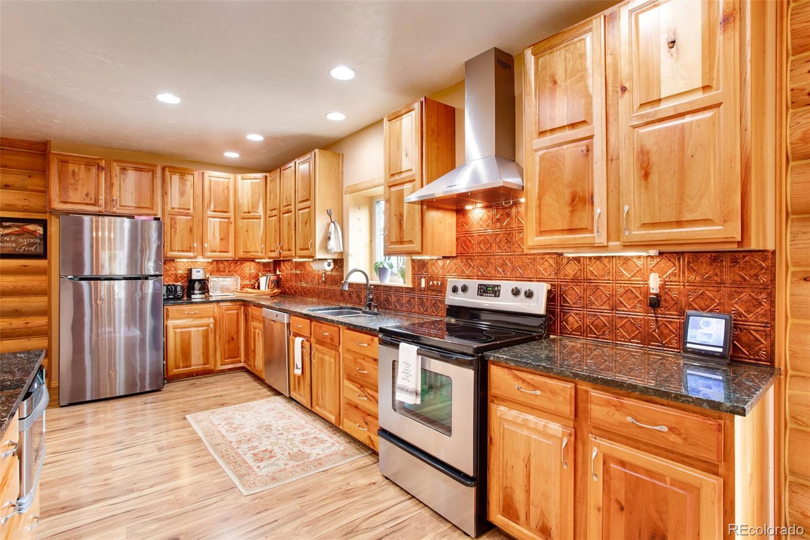 427 Wilderness Ridge Way Bellvue, CO 80512 - Photo 22 of 50 a kitchen with stainless steel appliances granite countertop a stove a sink and a refrigerator
