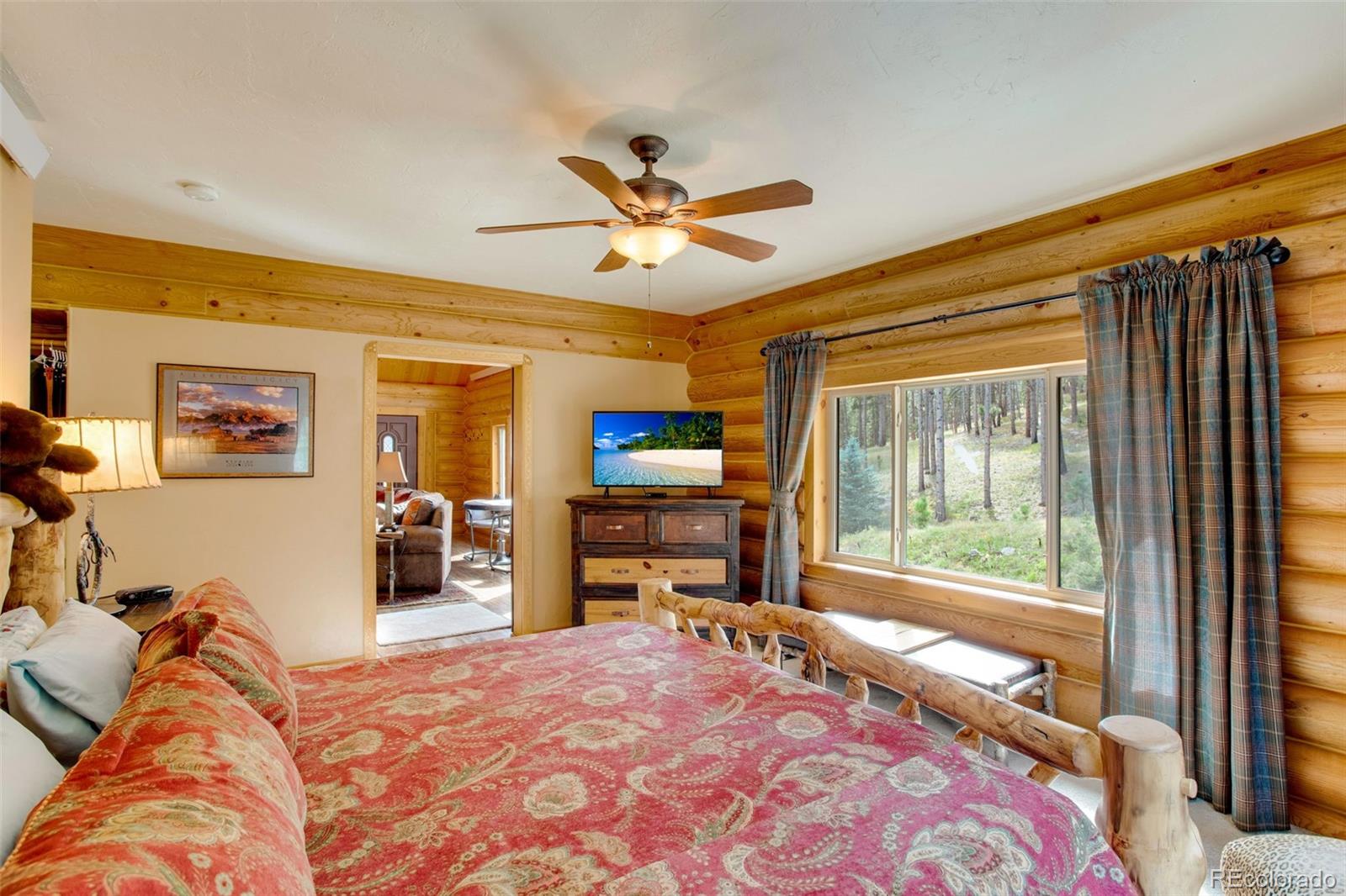 427 Wilderness Ridge Way Bellvue, CO 80512 - Photo 31 of 50 a bedroom with a bed and a large window with the outer view