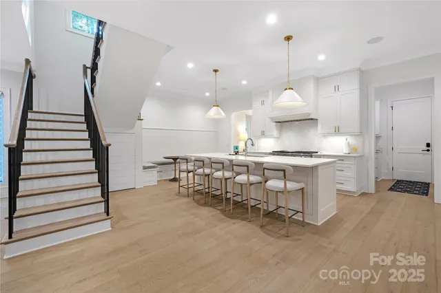 a kitchen with stainless steel appliances granite countertop a sink a stove and a wooden floors