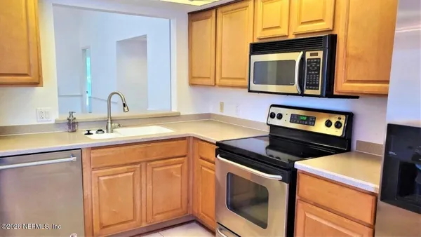 a kitchen with granite countertop a stove top oven microwave and cabinets