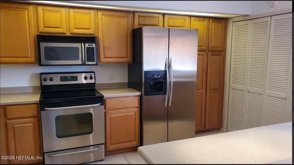a kitchen with stainless steel appliances a refrigerator stove and microwave