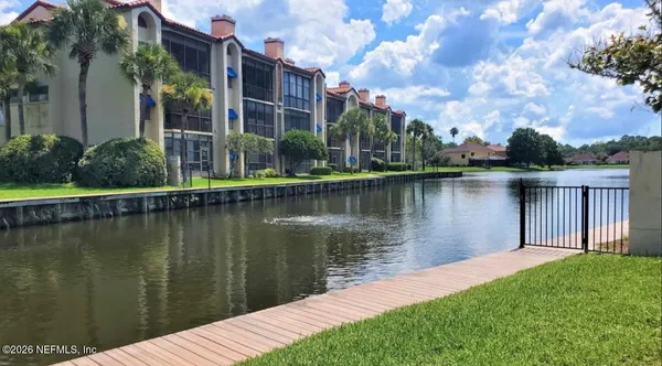 a lake view with a big yard and plants