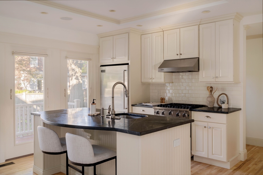 54 Orchard Street, Unit 1 Boston, MA 02130 - Photo 11 of 36 a kitchen with stainless steel appliances a sink a stove a table and chairs