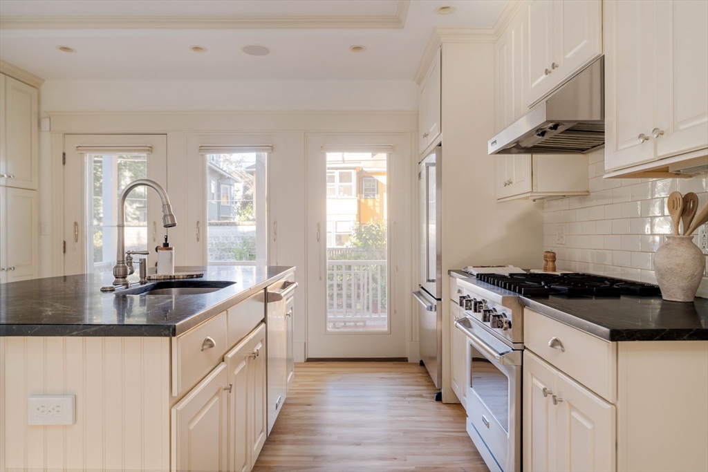 54 Orchard Street, Unit 1 Boston, MA 02130 - Photo 12 of 36 a kitchen with granite countertop a sink stove and cabinets