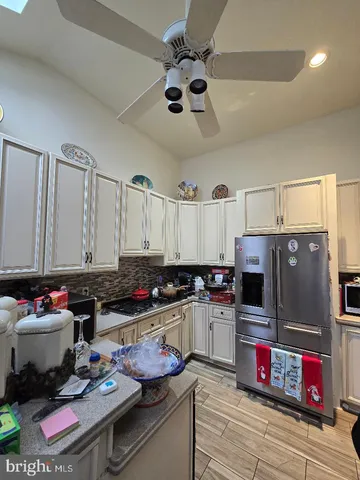 a kitchen with kitchen island granite countertop a sink appliances and cabinets