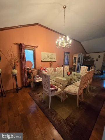 a living room with furniture a chandelier and a dining table
