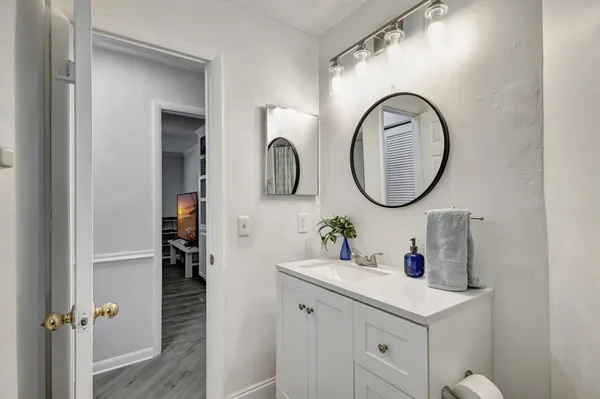 a bathroom with a toilet a double vanity sink and a mirror
