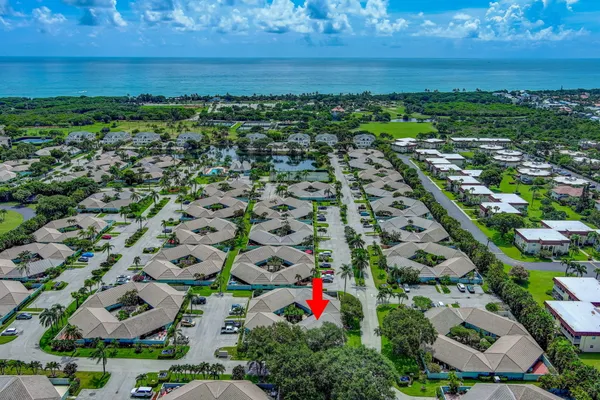 an aerial view of residential houses with outdoor space and ocean view