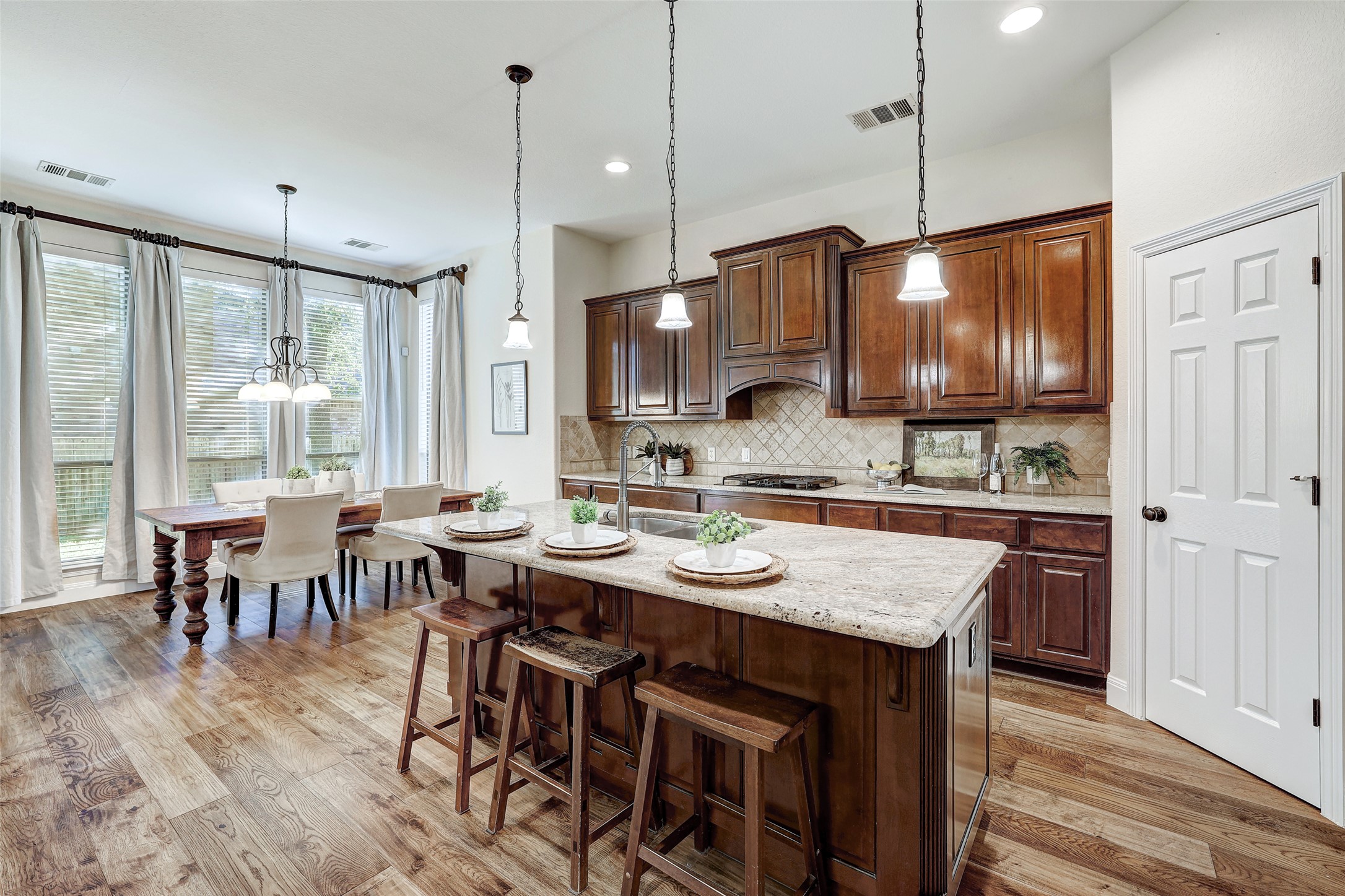 3600 Alexandrite Way Round Rock, TX 78681 - Photo 12 of 40 a kitchen with stainless steel appliances granite countertop a stove a refrigerator a kitchen island a sink cabinets and wooden floor