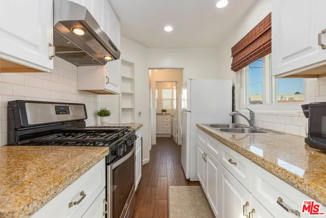 a bathroom with a granite countertop toilet sink and mirror