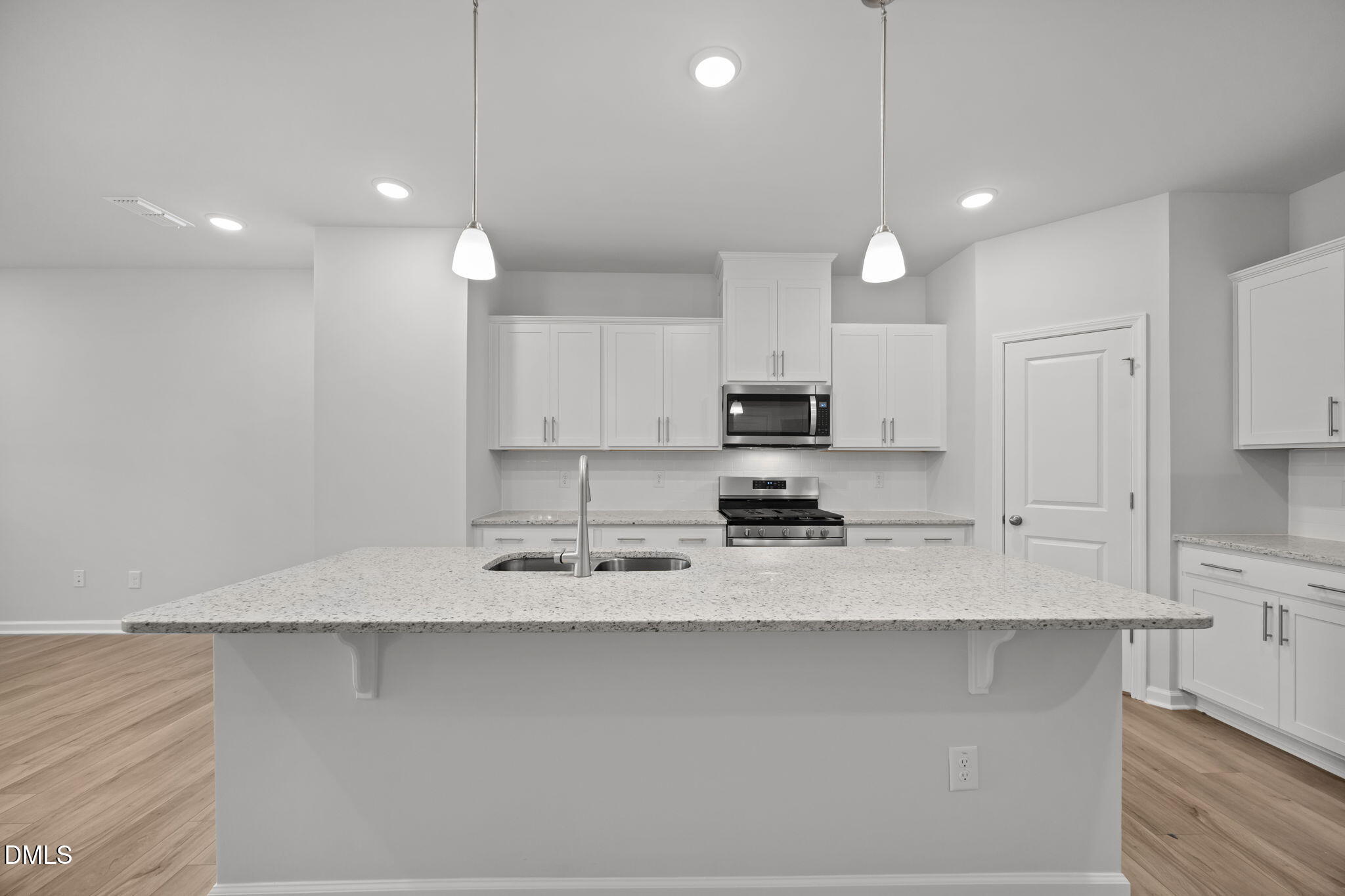 272 Fosterton Cottage Way Raleigh, NC 27603 - Photo 24 of 35 a large kitchen with kitchen island white cabinets and stainless steel appliances