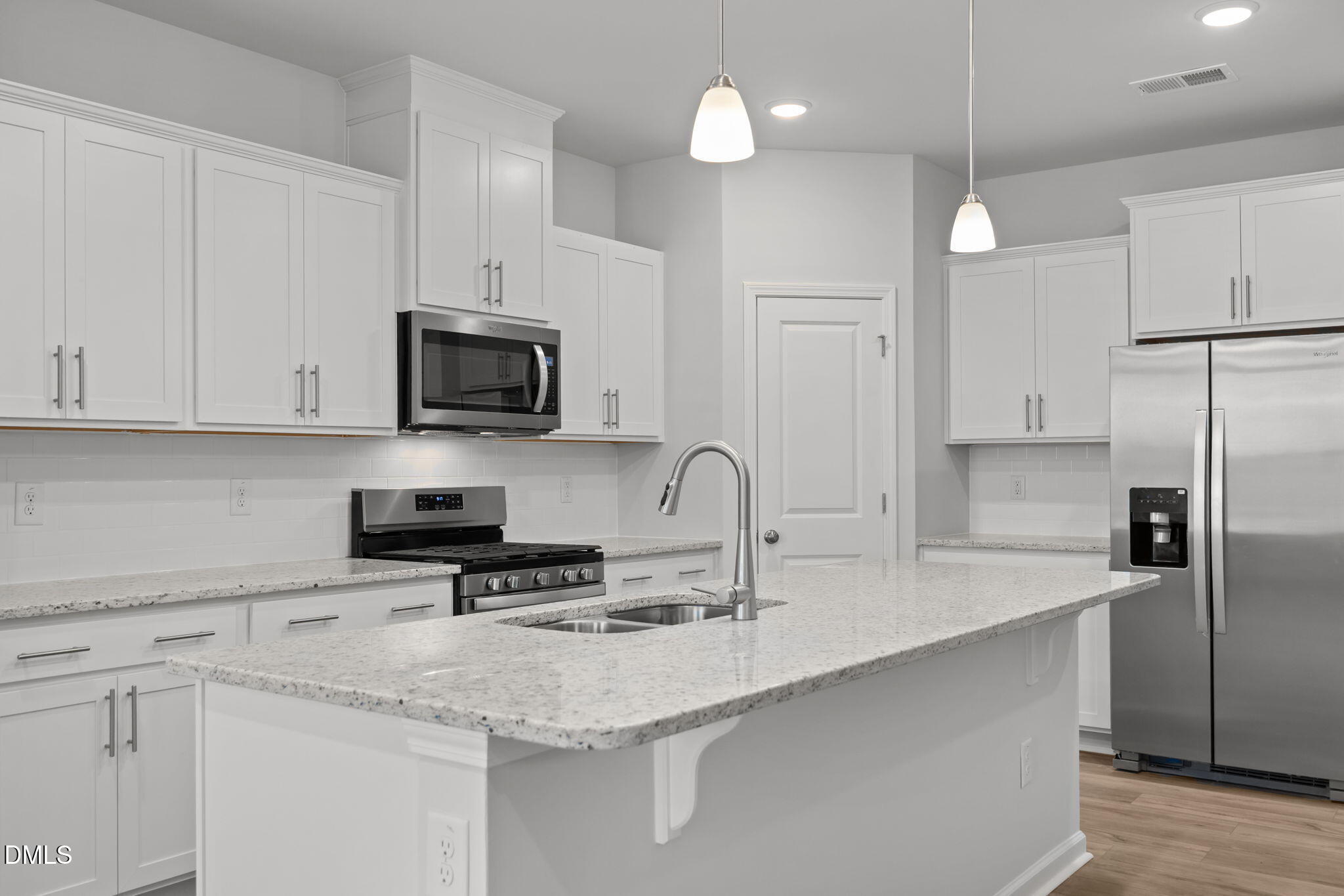 272 Fosterton Cottage Way Raleigh, NC 27603 - Photo 25 of 35 a kitchen with stainless steel appliances granite countertop a sink a stove a refrigerator a microwave a sink and white cabinets