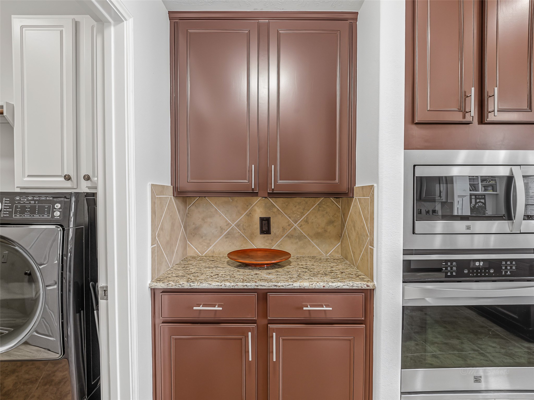 2210 Fox Path Katy, TX 77494 - Photo 23 of 47 Rich, deep espresso-toned cabinetry runs the length of the kitchen, providing an abundance of storage. The look is completed with modern, brushed nickel t-bar handles for a sleek, contemporary touch.