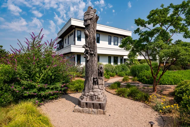 a front view of a house with a yard and potted plants