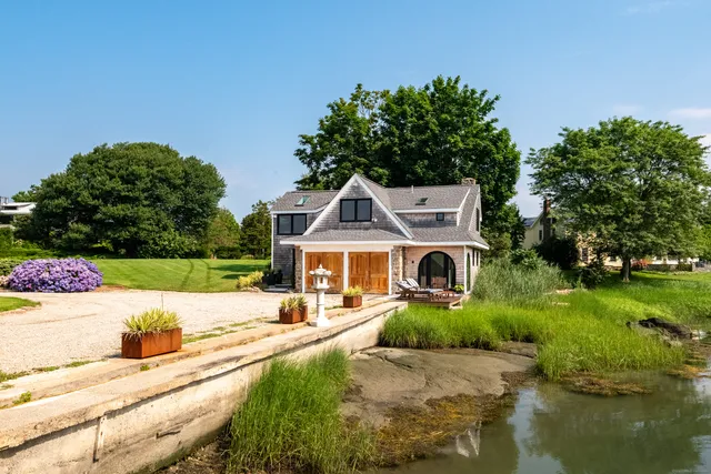 an aerial view of a house with a garden and lake view