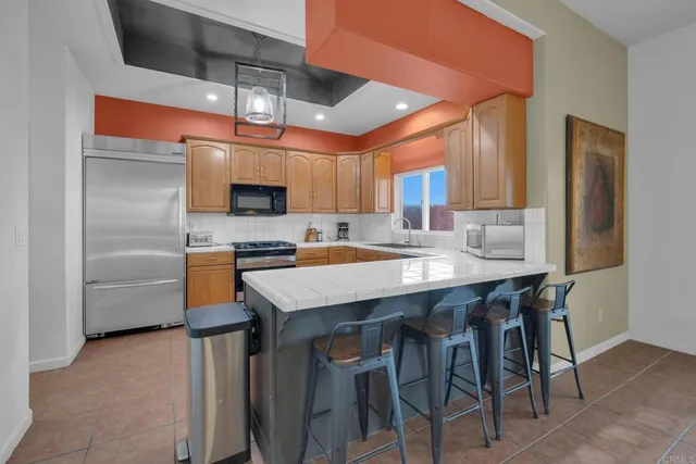 a kitchen with granite countertop a stove a sink and a refrigerator