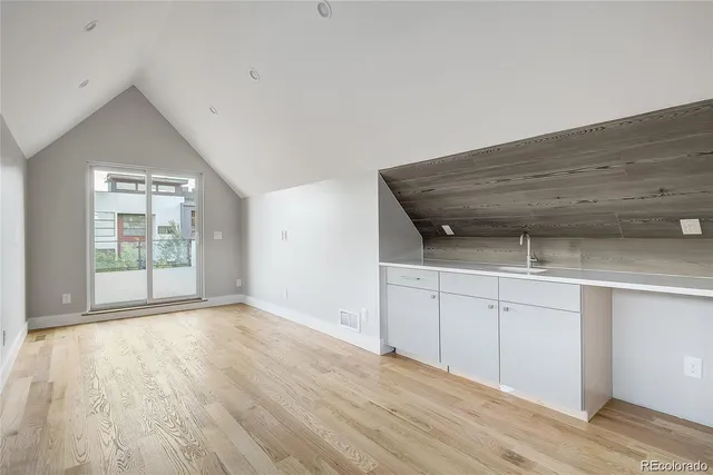 a view of a kitchen with wooden floor and a sink