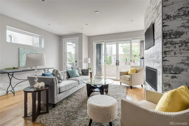 a living room with fireplace furniture and a large window