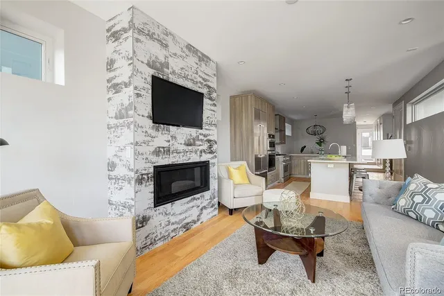 a living room with furniture a flat screen tv and a fireplace