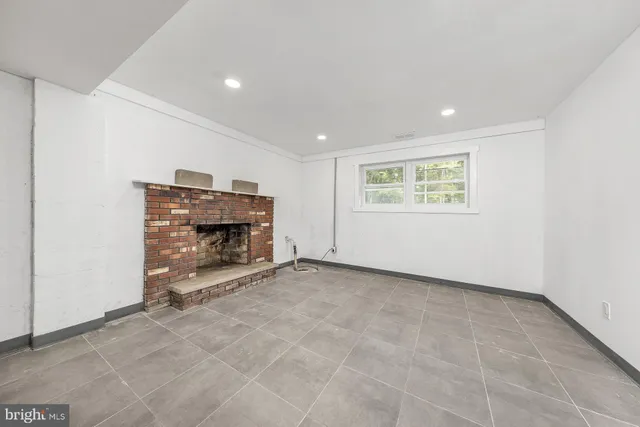 an empty room with fireplace and a window