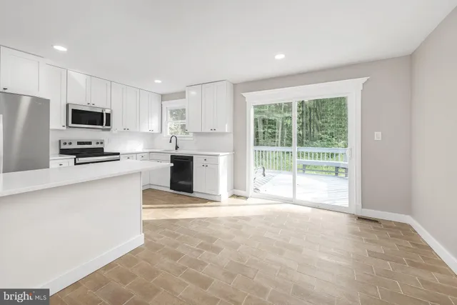 a large kitchen with cabinets and a stove top oven
