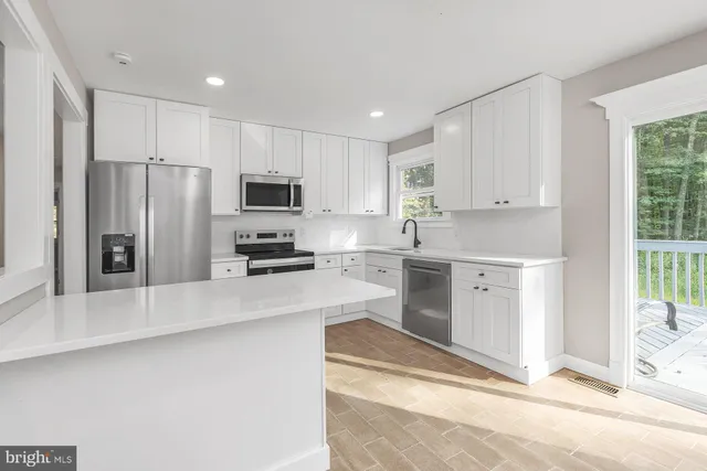 a kitchen with granite countertop a refrigerator and a stove top oven