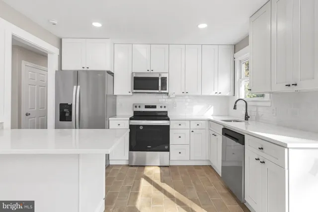 a kitchen with granite countertop a refrigerator stove and sink