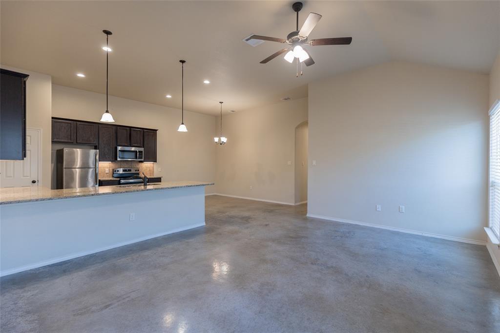 351 Joanne Loop, Unit A Buda, TX 78610 - Photo 6 of 17 An open-concept living area with a functional kitchen and high ceilings, ideal for modern living.